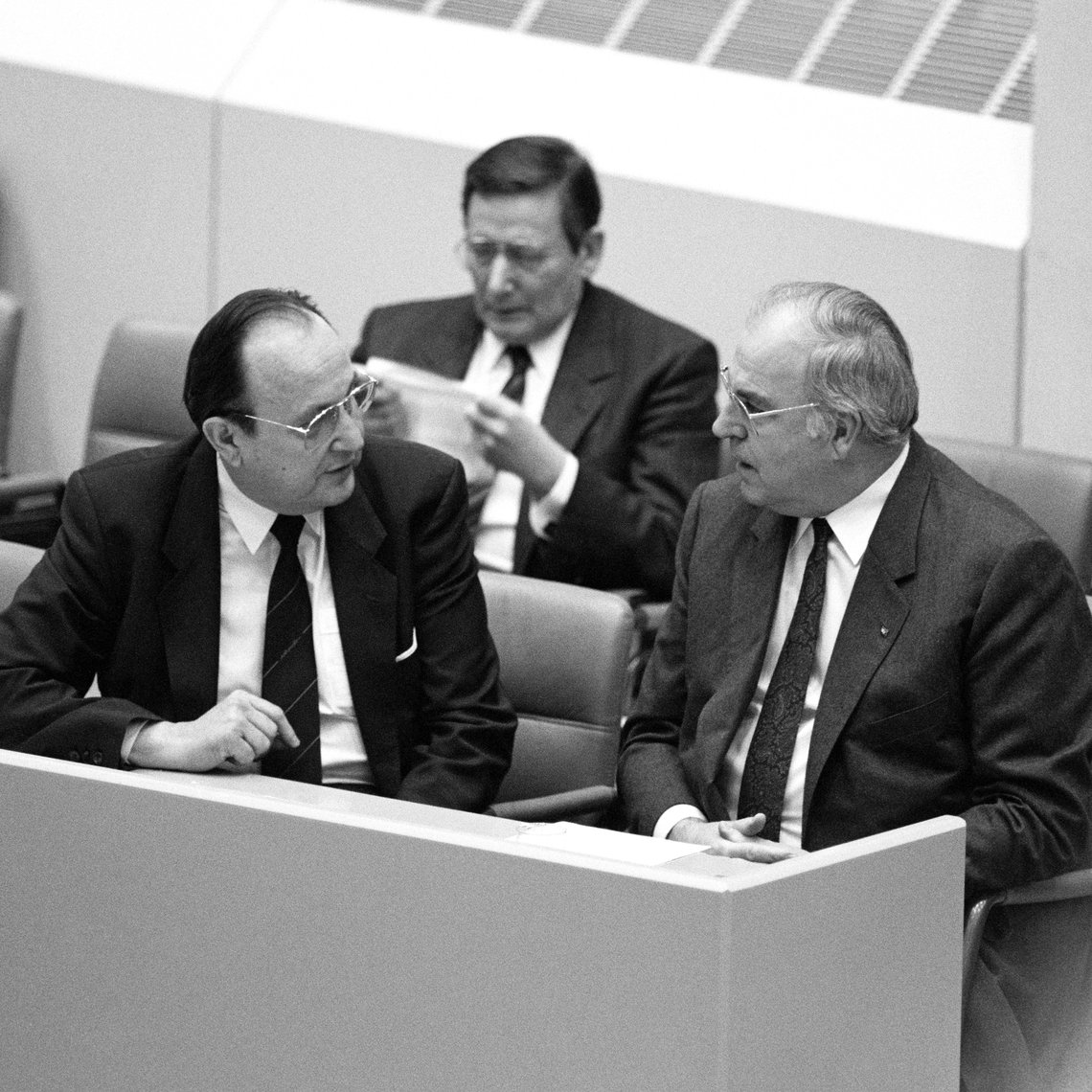 Schwarz-Weiss-Aufnahme von Helmut Kohl im Gespräch mit Hans-Dietrich Genscher in einer Bundestagssitzung