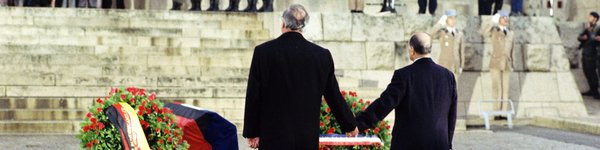 Aufnahme von Helmut Kohl mit François Mitterrand Hand in Hand vor Blumenkränzen