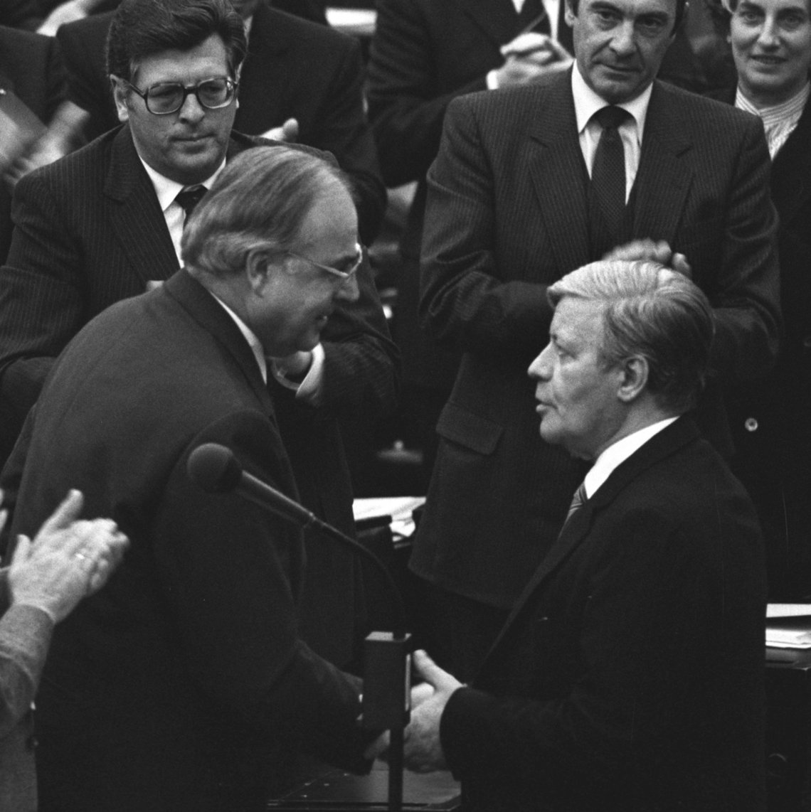 Schwarz-Weiss-Aufnahme von Helmut Schmid, wie er Helmut Kohl zu seiner Wahl zum Bundeskanzler gratuliert