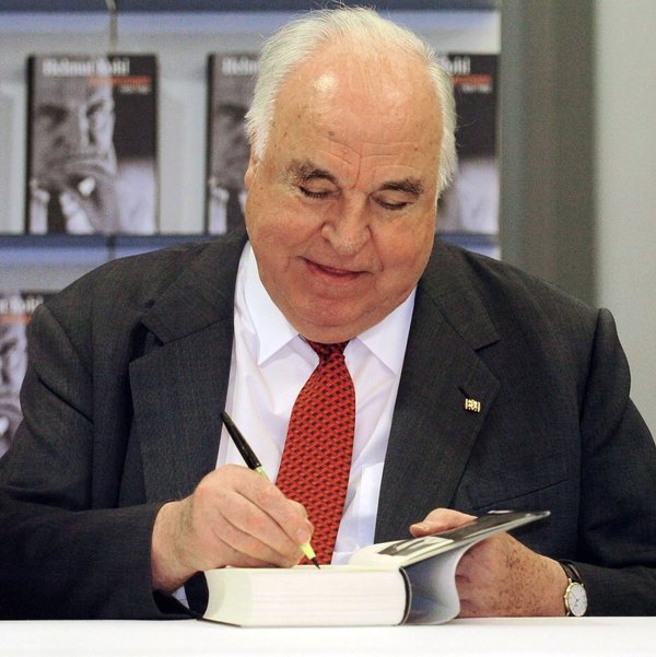 Helmut Kohl signiert ein Buch.