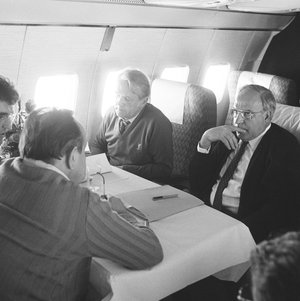 Schwarz-Weiss-Aufnahme von Horst Teltschik, Hans-Dietrich Genscher, Friedrich Ruth und Helmut Kohl im Flugzeug