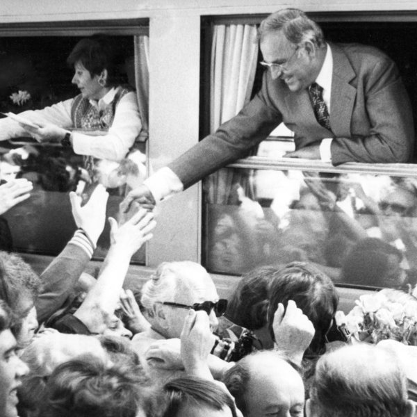 Schwarz-Weiss-Aufnahme von Helmut Kohl beim Grüßen umstehender Menschen aus einem Zugfenster